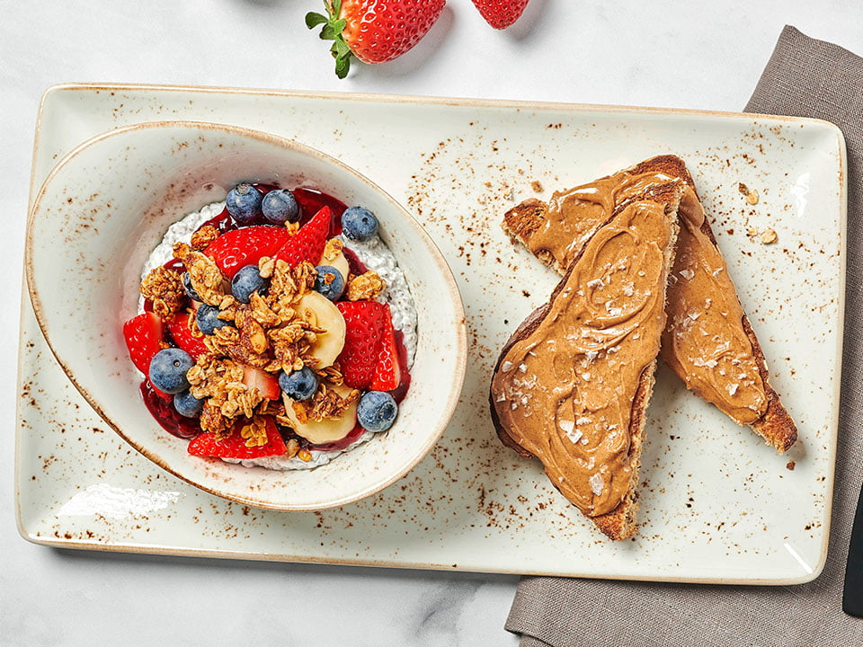 Coconut milk chia seed pudding, fresh bananas and berries, mixed berry compote, housemade granola with almonds and our whole grain artisan toast with almond butter and Maldon sea salt.