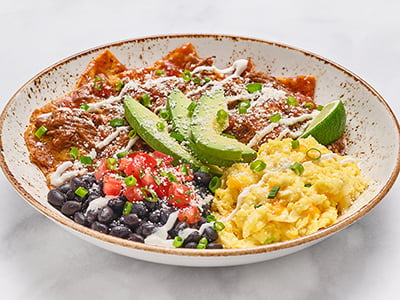 Seasoned braised beef Barbacoa tossed with salsa roja and crispy corn tortilla chips, topped with fresh avocado, lime crema, Cotija cheese and scallions. Served with scrambled cage-free eggs and seasoned black beans.