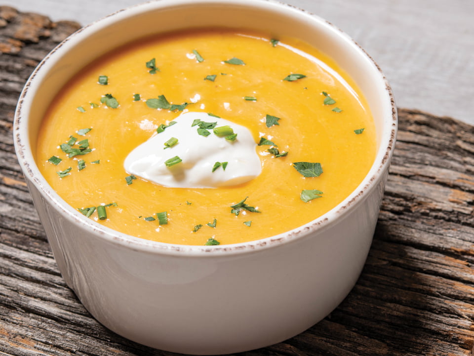 Rich and creamy butternut squash soup sweetened with carrot and a touch of nutmeg. Garnished with all-natural sour cream and fresh herbs.