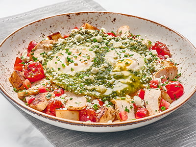 Two cage-free eggs basted in basil pesto, served over fresh, seasoned potatoes with grape tomatoes, sliced seasoned chicken breast and housemade pico de gallo. Topped with herbed Goat cheese and fresh herbs.
