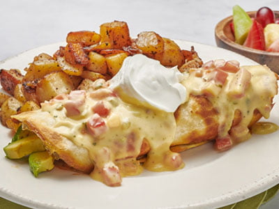 Whipped cage-free eggs with spicy, all-natural chicken breast, chorizo, green chiles, Cheddar and Monterey Jack, onions and avocado rolled in a flour tortilla. Topped with Vera Cruz sauce and all-natural sour cream. Served with fresh, seasoned potatoes.