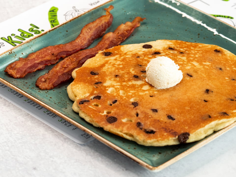 One of our humongous multigrain pancakes loaded with chocolate chips and topped with creamy butter. Served with your choice of bacon or sausage.