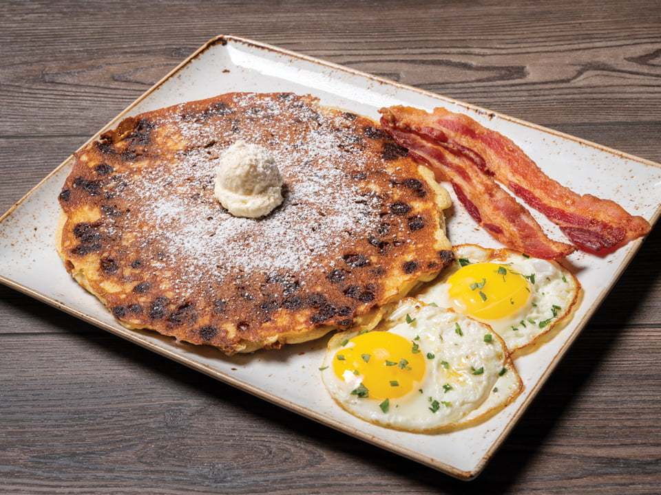 Two cage-free eggs cooked any style with a cinnamon chip pancake and your choice of hardwood smoked bacon or chicken, pork or turkey sausage.