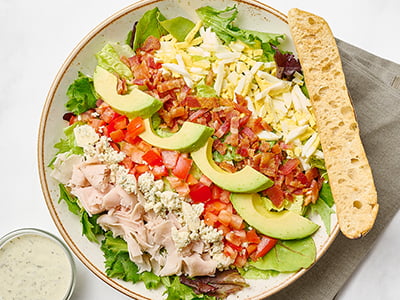 Organic mixed greens, bacon, turkey breast, a hard-boiled cage-free egg, tomatoes, avocado and Bleu cheese crumbles with buttermilk ranch dressing.