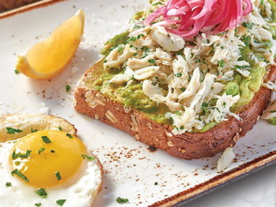 Wild-caught lump crab and fresh smashed avocado on top of our whole grain artisan toast with house-pickled red onions, EVOO, fresh herbs and Maldon sea salt. Served with two basted cage-free eggs. 