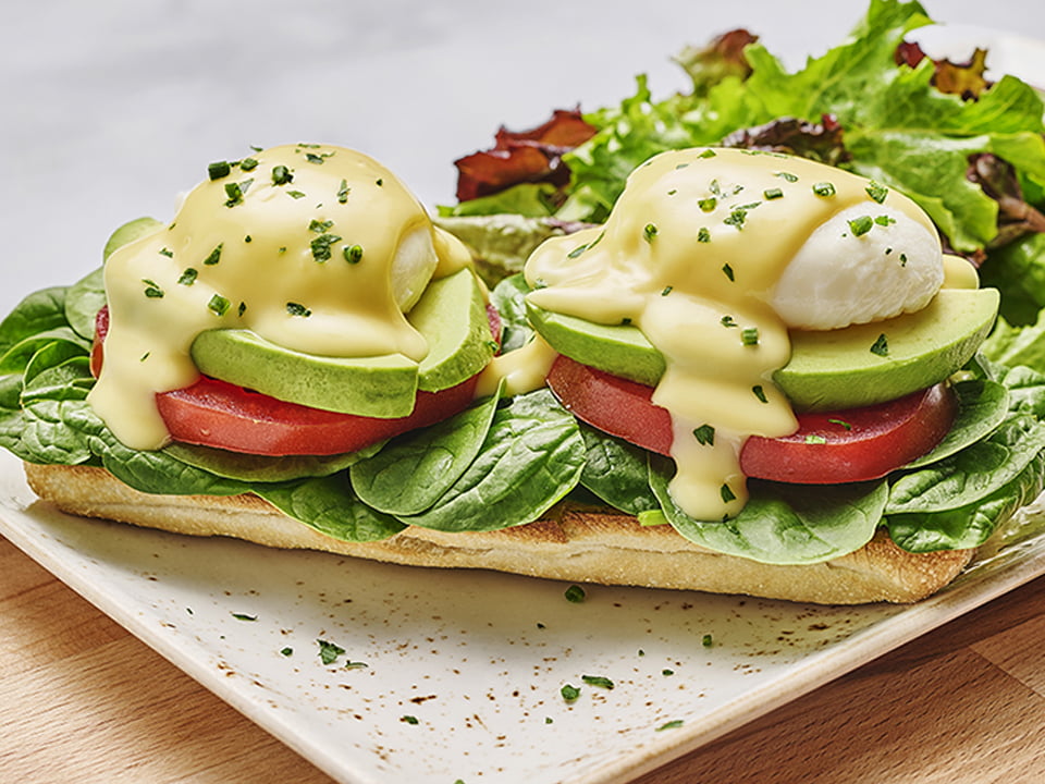 Two poached cage-free eggs atop toasted ciabatta with fresh baby spinach, avocado and vine-ripened tomato and covered with hollandaise. Served with lemon-dressed organic mixed greens.