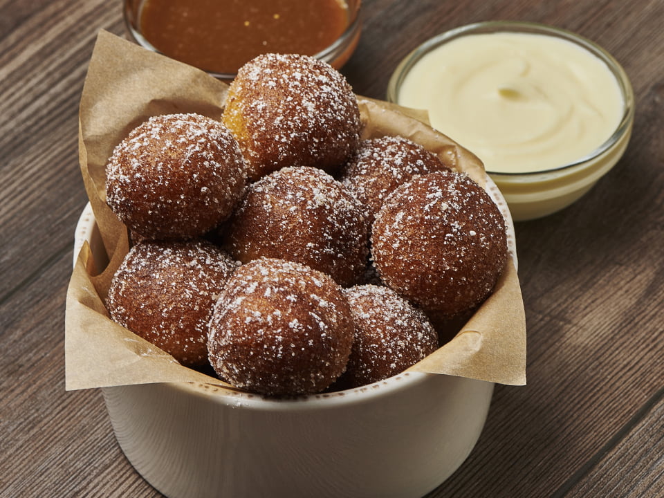 Warm cake donut holes tossed with gingerbread spice and lightly dusted with powdered cinnamon sugar. Served with salted caramel toffee sauce and creme anglaise.