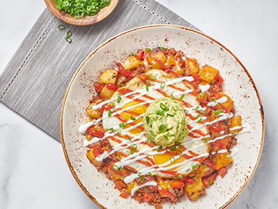 Chorizo, red bell pepper and potato hash topped with two cage-free eggs any style, Cheddar and Monterey Jack, spicy ketchup, lime crema drizzle, fresh smashed avocado and scallions.