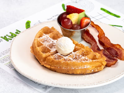 A half portion of our fluffy Belgian waffle. Served with fresh fruit and your choice of bacon or sausage.