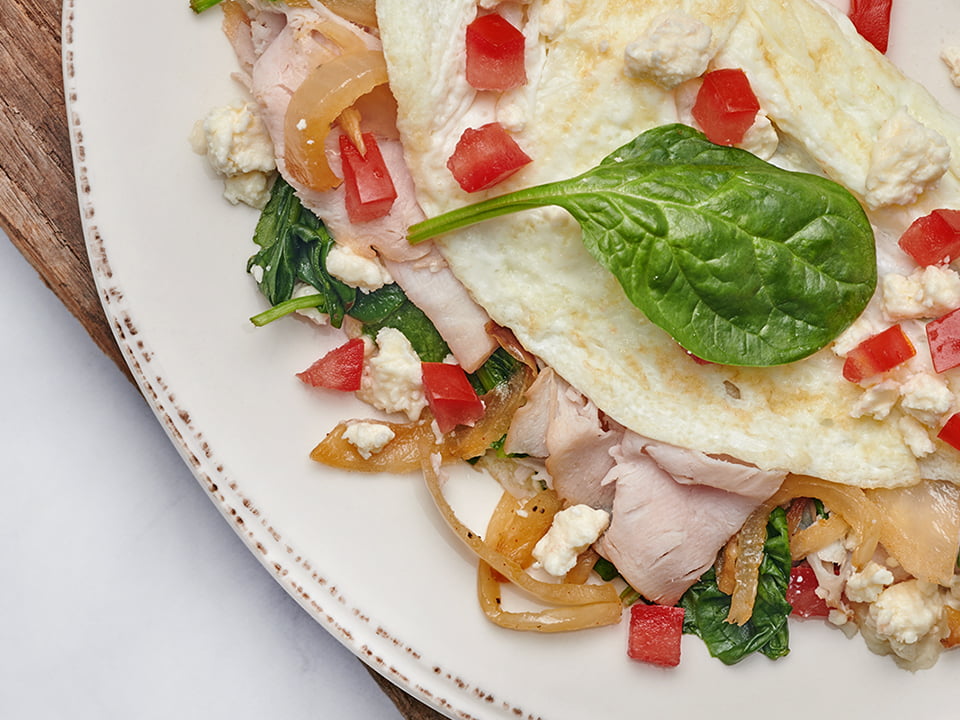 Turkey, house-roasted onions, tomatoes, spinach and Feta cheese in a cage-free egg white omelet. Served with our whole grain artisan toast and all-natural house preserves.