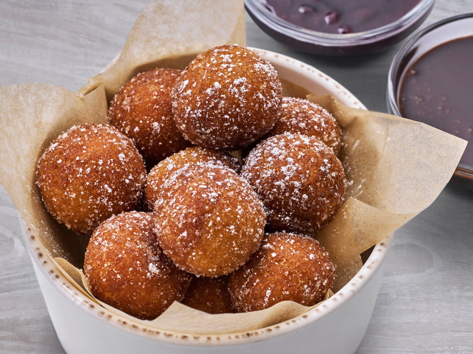 Cinnamon sugar-dusted cake donut holes with chocolate sauce and warm mixed berry compote for dipping.