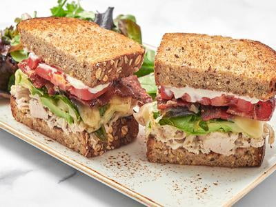 Hand-pulled roasted turkey, Million Dollar Bacon, spring mix, tomato, fresh avocado, Monterey Jack and mayo on our whole grain artisan toast with a side of lemon-dressed organic mixed greens.