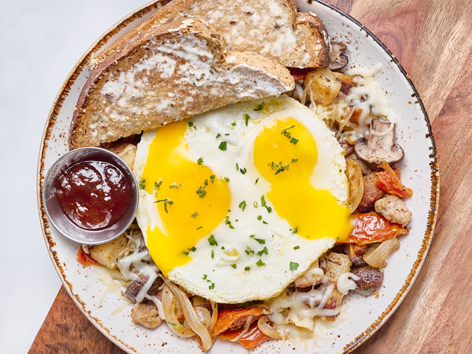 Two cage-free eggs any style atop fresh, seasoned potatoes, Italian sausage, house-roasted Crimini mushrooms, onions and tomatoes with melted Parmesan, Mozzarella and fresh herbs. Served with our whole grain artisan toast.