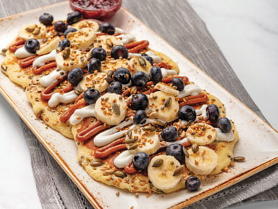 Flax, hemp, kasha, pepitas and sunflower seeds added to our multigrain pancake batter. Served as three mid-sized pancakes topped with fresh, sliced bananas, blueberries, maple-almond butter, vanilla Greek yogurt and superseed crunch. Served with warm mixed berry compote.
