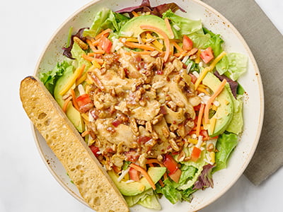 Organic mixed greens, romaine, all-natural chicken breast, bacon, toasted pecans, avocado, tomatoes and carrots with Cheddar and Monterey Jack. Drizzled with warm honey Dijon dressing.