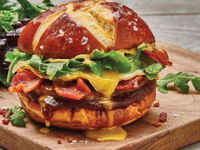 A savory pork sausage patty, hardwood smoked bacon and melted Gruyere cheese with an over-easy cage-free egg, apple butter, arugula and Dijon mustard on a griddled pretzel bun. Served with lemon-dressed organic mixed greens.