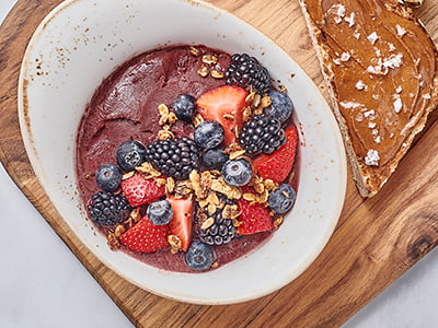 Organic SAMBAZON Acai (ah-sigh-EE) topped with fresh strawberries, blackberries, blueberries and our housemade granola with almonds. Served with our whole grain artisan toast topped with almond butter and Maldon sea salt.