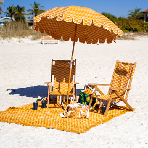 Orange umbrella, two chairs, and a towel on the sand