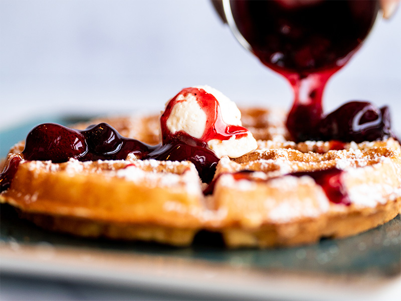 Airy Belgian waffle with a side of warm, berry compote